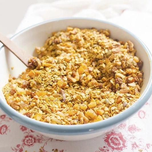 bowl of sweet debbie's sugar-free, gluten-free and organic golden glow crunch granola with golden berries, sprouted walnuts, sprouted almonds and hojicha green tea 